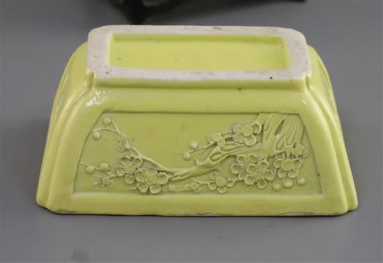 A Chinese yellow glazed biscuit model jardiniere, Qing dynasty, L. 10.3cm, wood stand